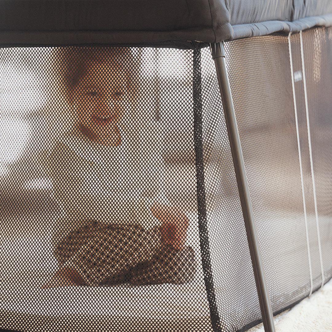 BabyBjörn Travel Cot Light in black, lightweight and easy-to-fold portable crib with breathable mesh sides, available for rental