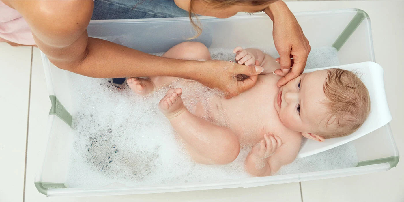 Stokke Flexi Bath with baby model – Comfortable, secure bathing solution for infants, available through Thursday’s Child Rental.