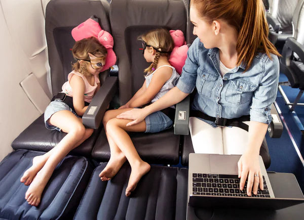 Two siblings sharing row with Plane Pal set up — stress-free family flying