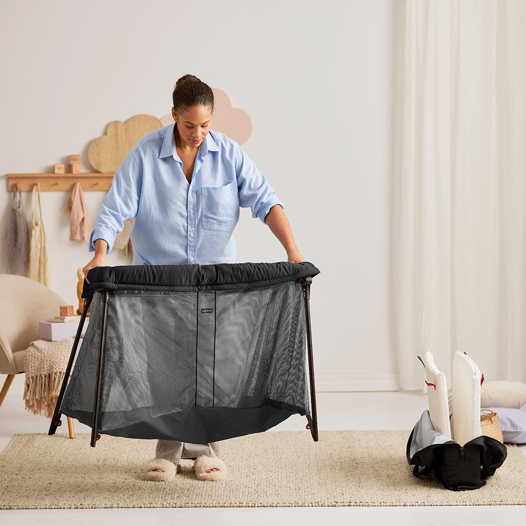 BabyBjörn Travel Cot Light in black, lightweight and easy-to-fold portable crib with breathable mesh sides, available for rental