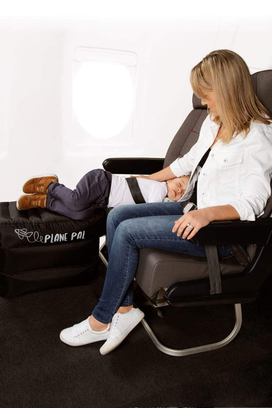 Happy toddler sleeping with Plane Pal on long-haul flight — rent from Thursday’s Child