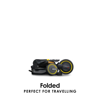 Folded black Doona Liki Trike S5 for travel or storage — ultra-compact design for families on the go, offered by Thursday’s Child Rental.