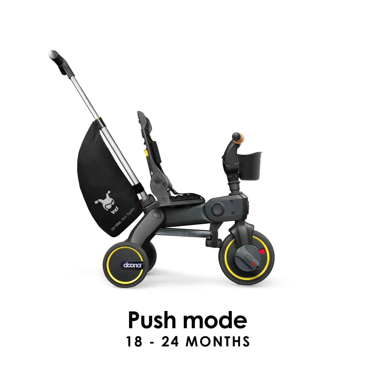 Doona Liki Trike S5 in black used in push mode with parent handlebar extended — toddler-friendly trike with stroller-style control available at Thursday’s Child Rental.