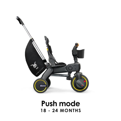 Doona Liki Trike S5 in black used in push mode with parent handlebar extended — toddler-friendly trike with stroller-style control available at Thursday’s Child Rental.