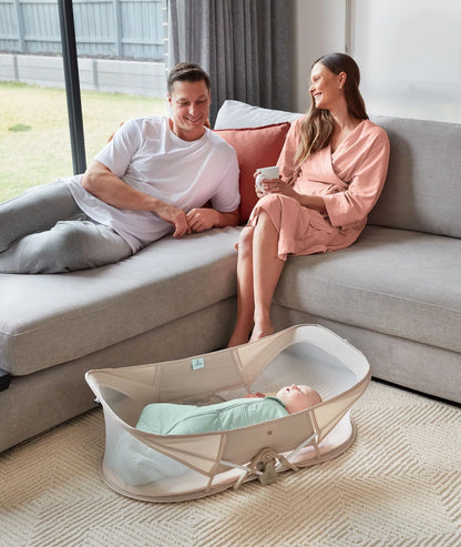 Toddler napping peacefully in travel-friendly Easy Sleep Crib with soft Ecru bedding.