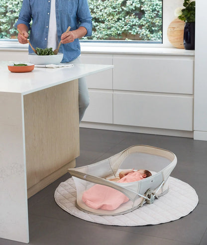 Toddler napping peacefully in travel-friendly Easy Sleep Crib with soft Ecru bedding.
